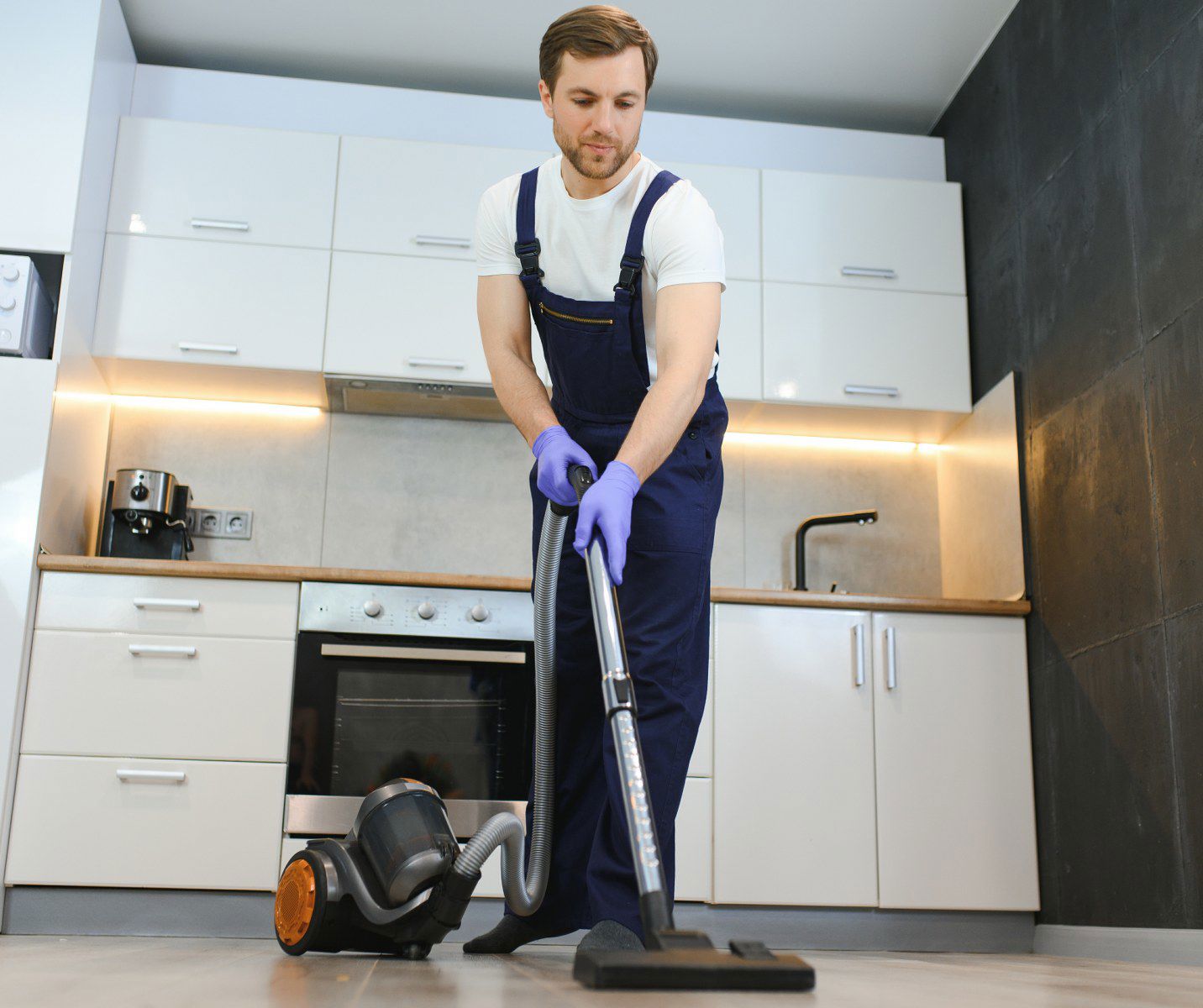 Happy Male Janitor Cleaning Carpet With Vacuum Cle 2024 01 04 21 14 20 Utc 1 1432X1200